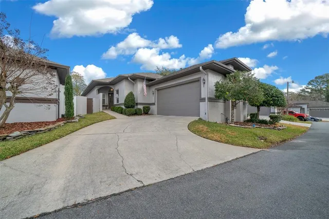 a view of a white house with a yard and potted plants