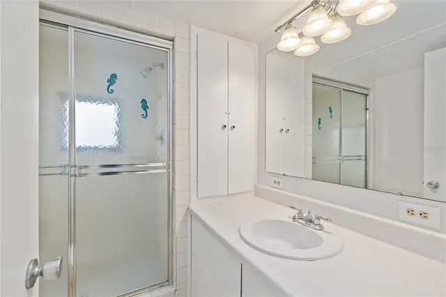 a bathroom with a sink a light fixture and a mirror