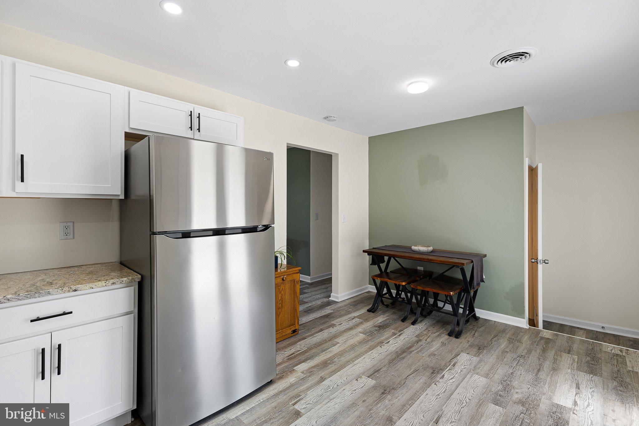 370 Big Elk Chapel Road Elkton, MD 21921 - Photo 10 of 29 a kitchen with a refrigerator a table and chairs