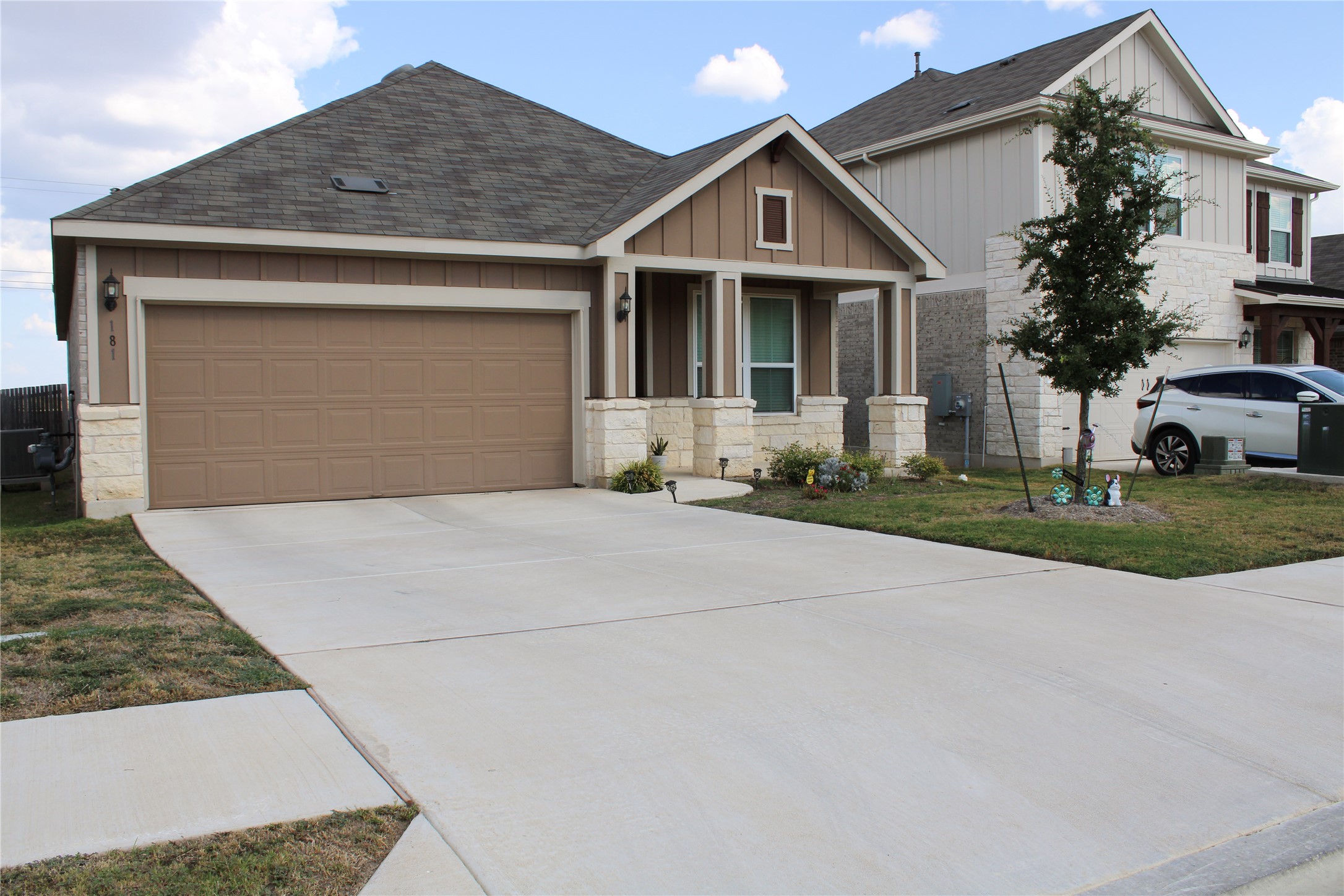 An inviting front porch and stone-accented columns define the exterior of this modern home.
