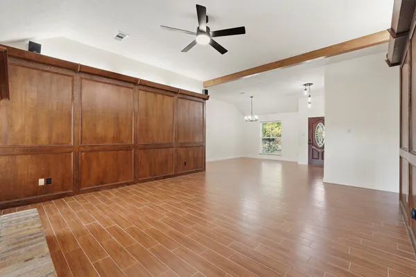 an empty room with window and ceiling fan