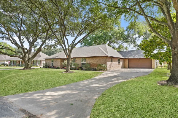 a front view of a house with a yard and an trees