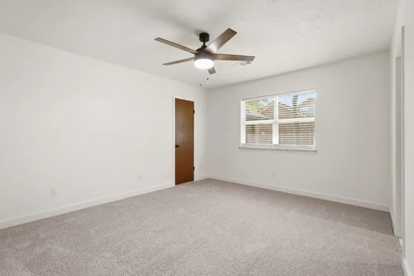 a view of a livingroom with a ceiling fan and window