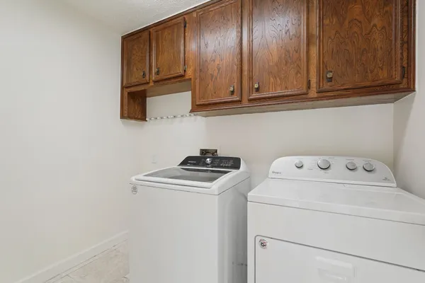 a living room with furniture a dining table and chairs with potted plants