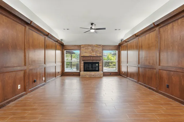an empty room with window and ceiling fan