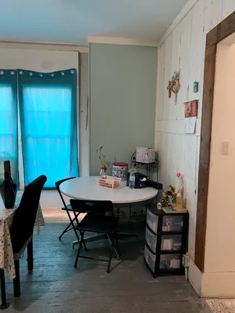 a bedroom with a bed and a refrigerator