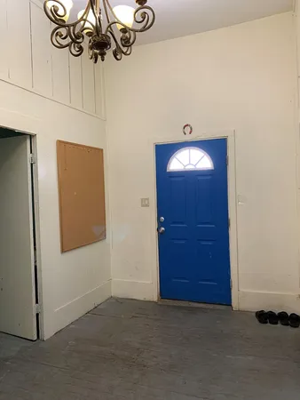 a view of a hallway with a chandelier fan and wooden floor