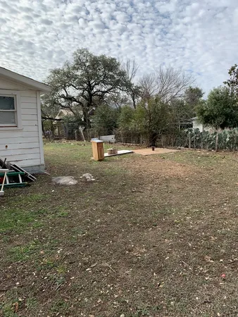 a front view of house with yard and trees in the background
