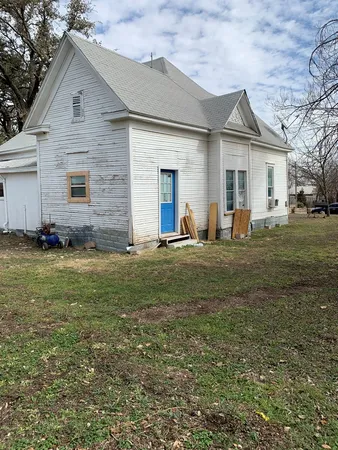 a front view of house with yard and trees around