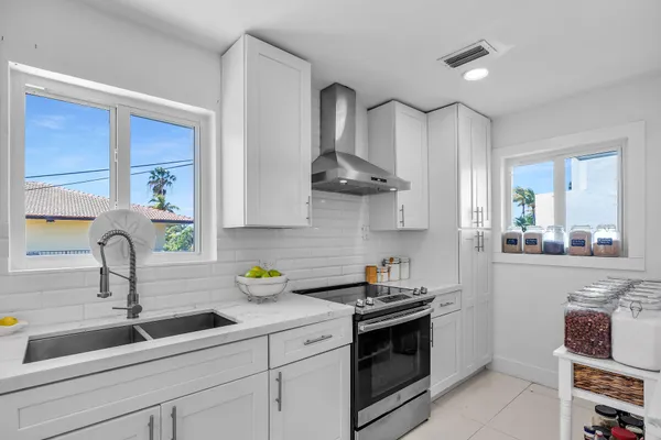 a kitchen with stainless steel appliances a sink stove and cabinets