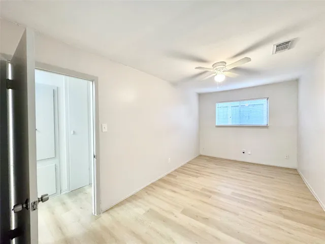 an empty room with fan and windows