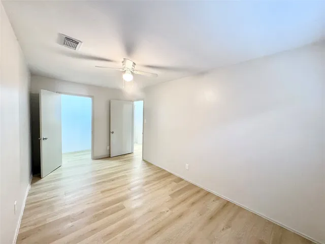 a view of an empty room with a ceiling fan