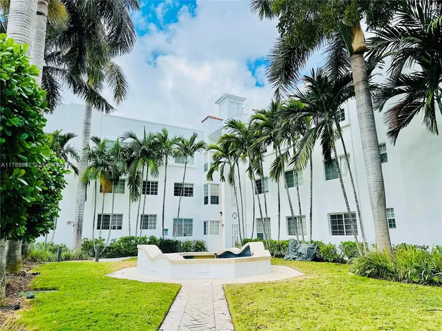 a view of a house with a yard and palm trees