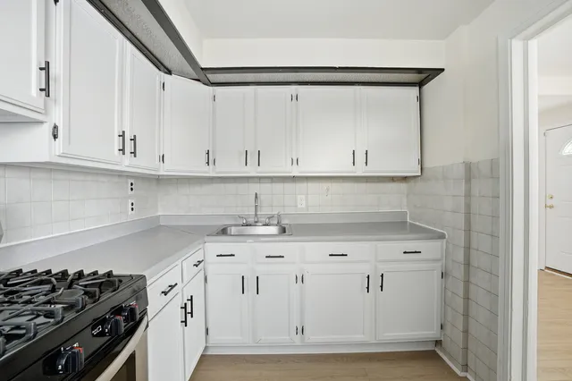 a kitchen with white cabinets and a stove
