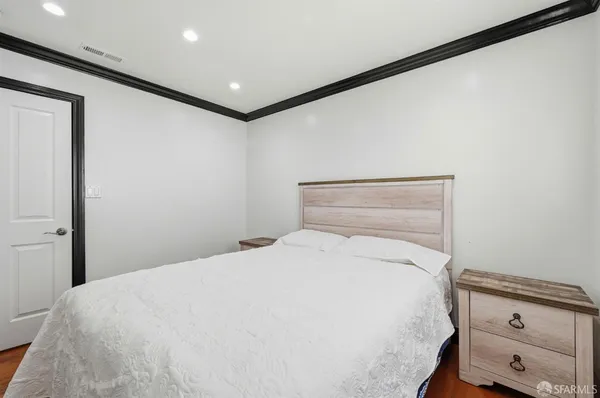 a bedroom with a bed a chandelier and a window