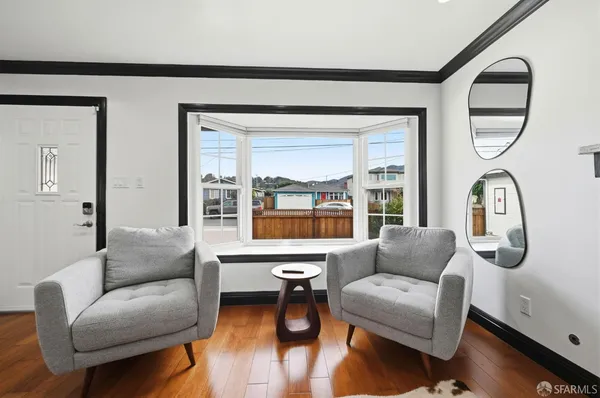 a living room with furniture wooden floor and a large window