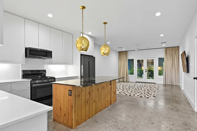 a kitchen with stainless steel appliances granite countertop a stove a sink and a refrigerator