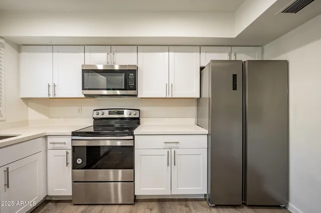 a kitchen with white cabinets and stainless steel appliances