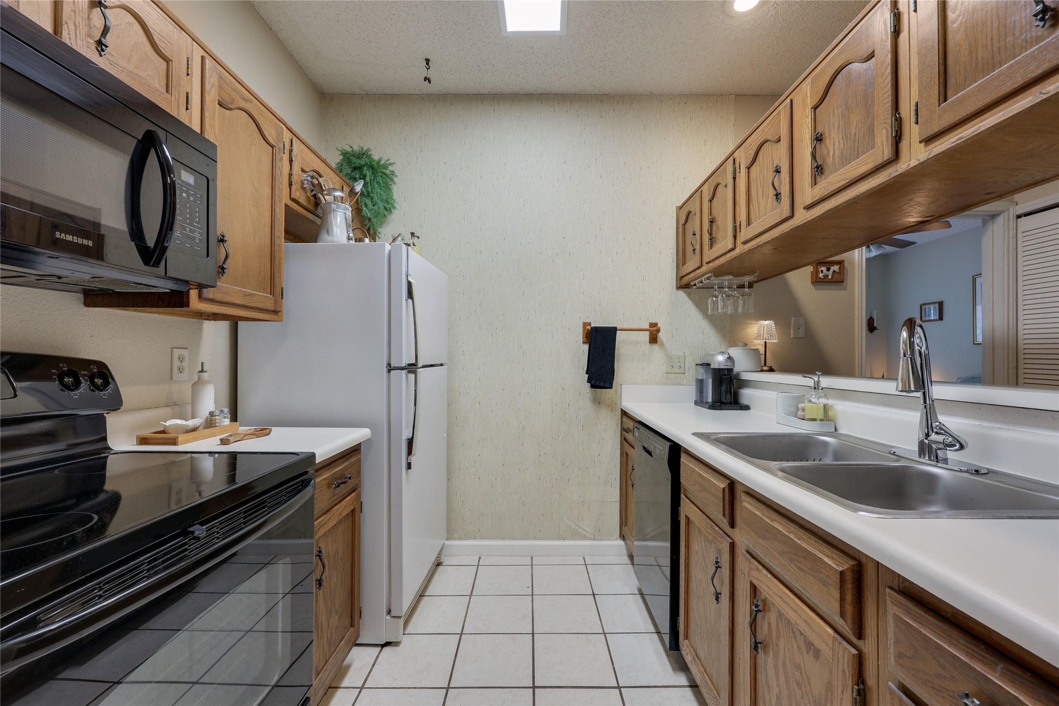3011 Fruth Street, Unit 101 Austin, TX 78705 - Photo 6 of 14 A compact kitchen with functional wood cabinetry and a full suite of appliances.