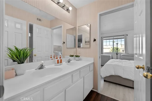 a en suite bathroom with a double vanity sink and mirror