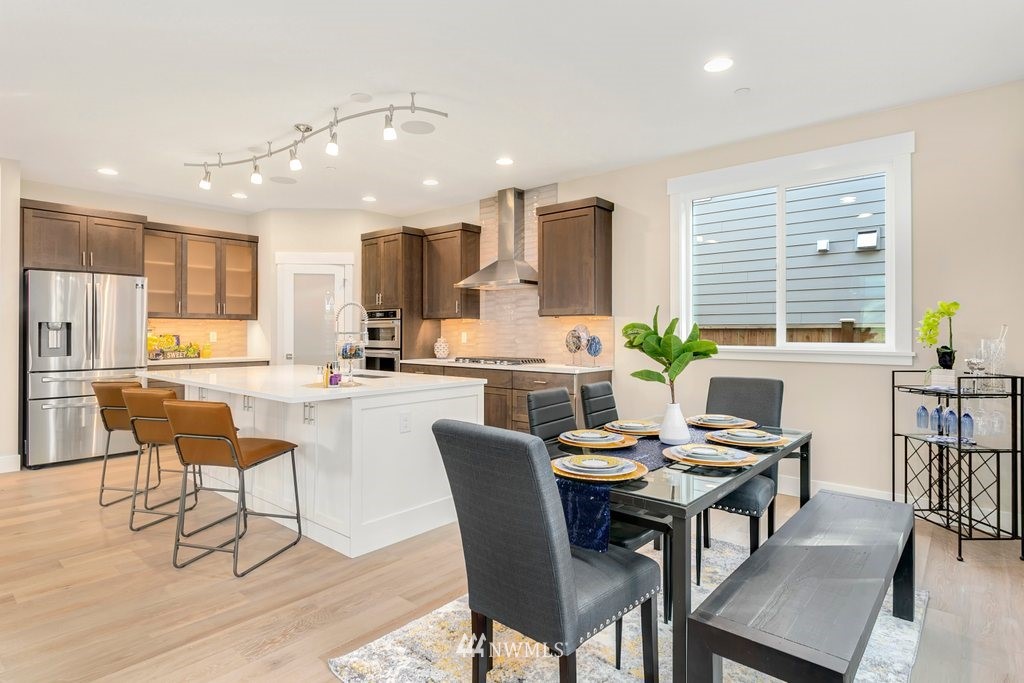900 232nd Street Southeast, Unit 3 Bothell, WA 98021 - Photo 8 of 25 a open dining room with stainless steel appliances kitchen island granite countertop a dining table chairs and a refrigerator