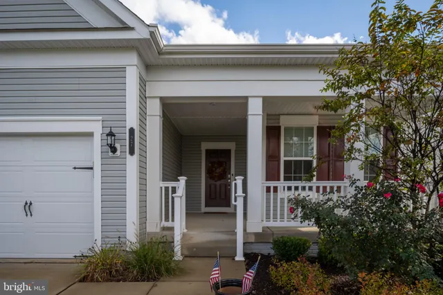 a hallway with a lots of frames on wall and a baby crib