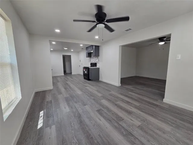 a view of empty room with wooden floor and window