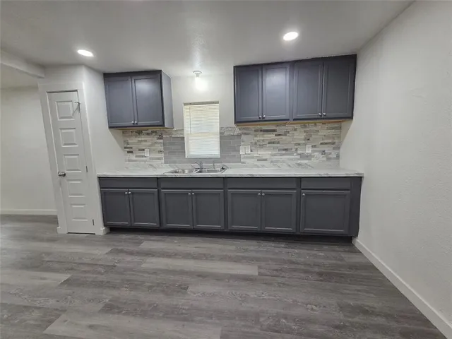 a view of kitchen with granite countertop a sink wooden cabinets and stainless steel appliances