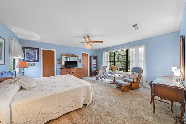 a bedroom with a bed and large windows