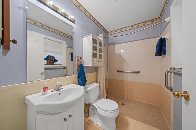 a bathroom with a sink mirror toilet and shower
