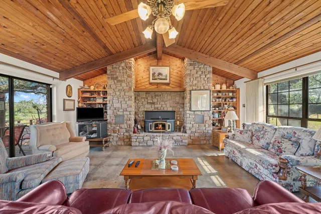 a living room with furniture a large window and a fireplace