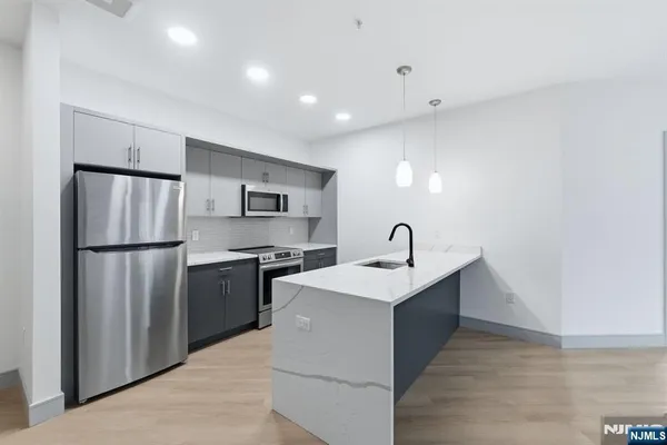 a kitchen with stainless steel appliances a sink stove and refrigerator