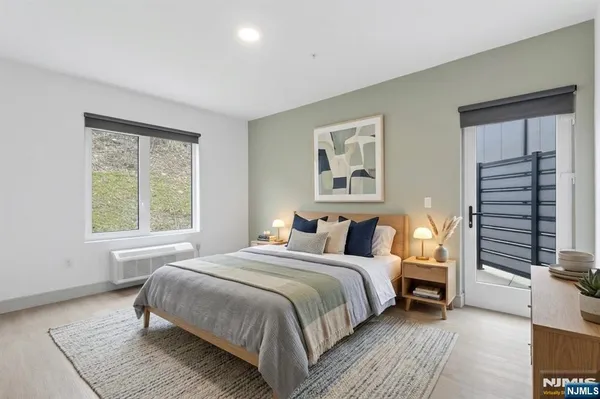 a bedroom with a bed wooden floor and window