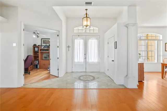 a view of a livingroom with wooden floor and a kitchen space