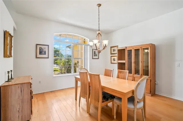 a dining room with wooden floor and chandelier