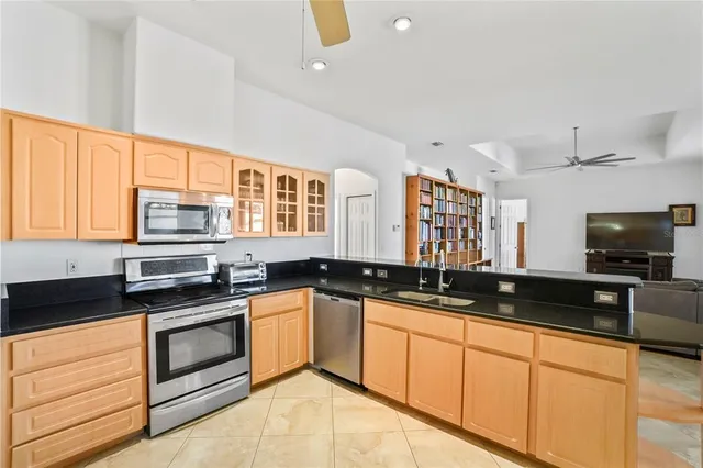 a kitchen with stainless steel appliances granite countertop a refrigerator a stove and a sink