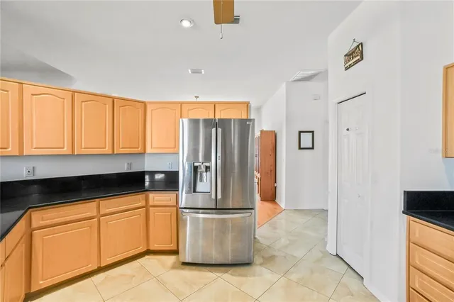 a kitchen with stainless steel appliances granite countertop a refrigerator a stove and a sink with wooden floor