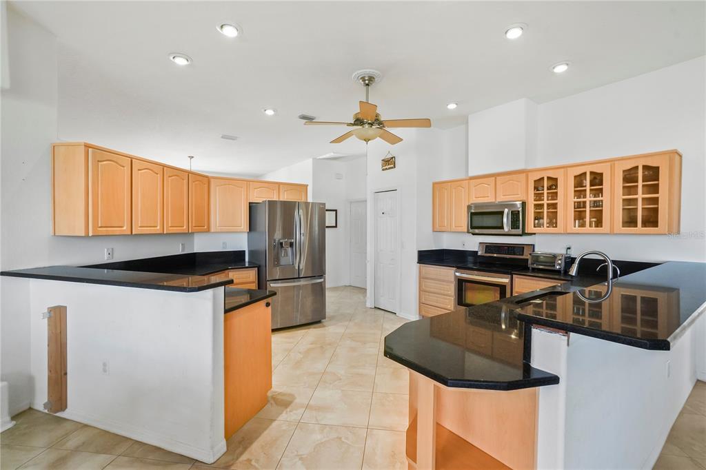 3441 Cedar Crest Loop Spring Hill, FL 34609 - Photo 22 of 58 a kitchen with stainless steel appliances granite countertop a sink a stove and a refrigerator