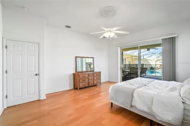 a bedroom with a large bed and wooden floor