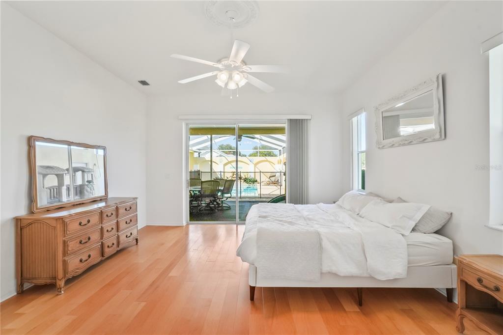 3441 Cedar Crest Loop Spring Hill, FL 34609 - Photo 30 of 58 a bedroom with a large bed and wooden floor