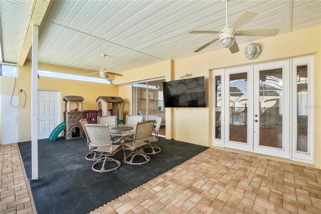 3441 Cedar Crest Loop Spring Hill, FL 34609 - Photo 32 of 58 a dining room with furniture a rug a flat screen tv and outdoor space