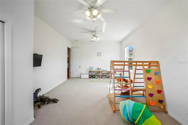 a bedroom with a bed table and flat screen tv