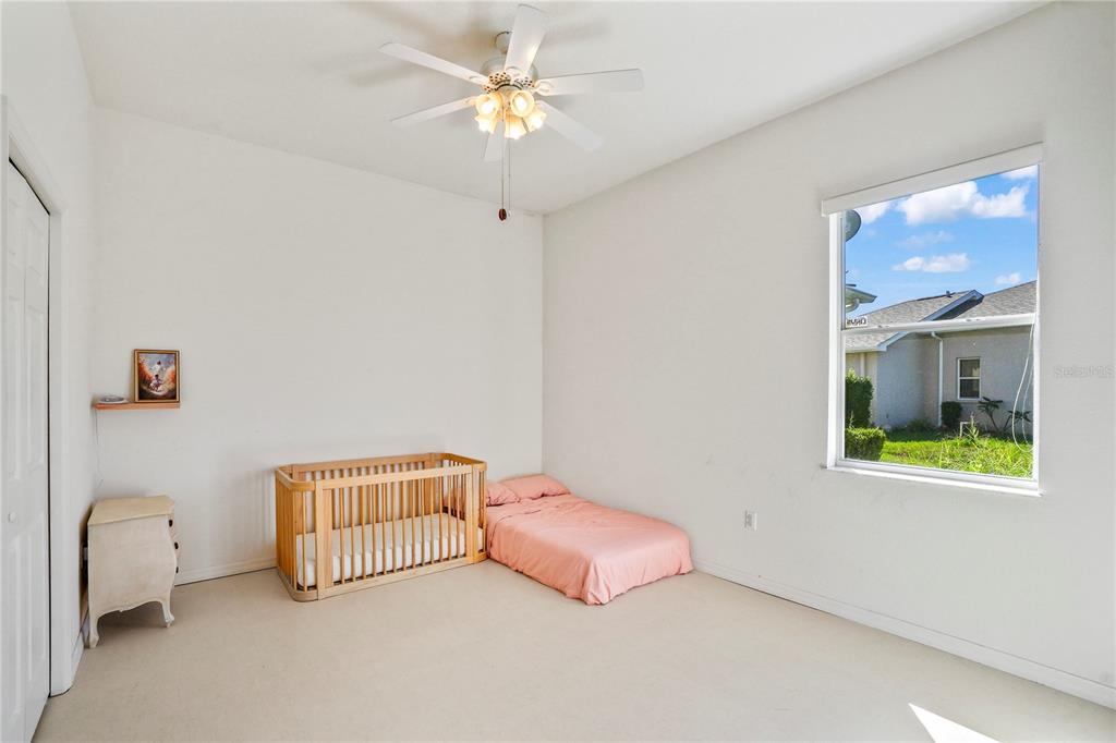 3441 Cedar Crest Loop Spring Hill, FL 34609 - Photo 43 of 58 a room with a bed and a chandelier