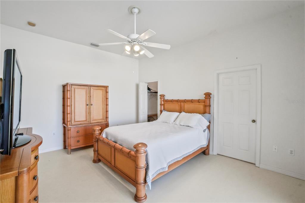 3441 Cedar Crest Loop Spring Hill, FL 34609 - Photo 45 of 58 a bedroom with a bed table and flat screen tv