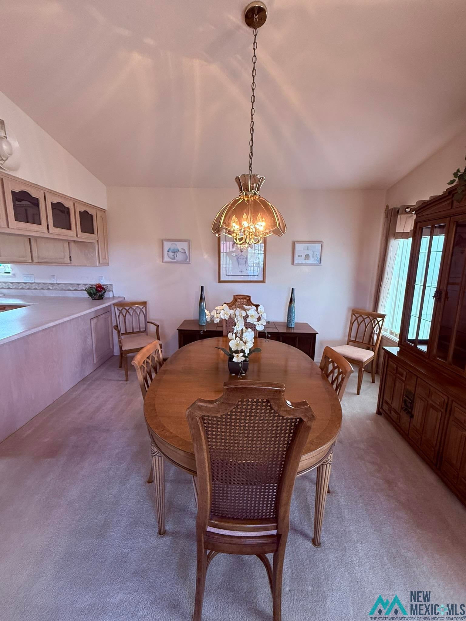 300 Rio Grande Circle Elephant Butte, NM 87935 - Photo 57 of 99 Dining area featuring an ornate chandelier, vaulted ceiling, and light-colored carpeting
