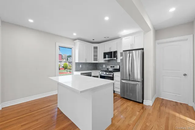 a kitchen with refrigerator cabinets and wooden floor