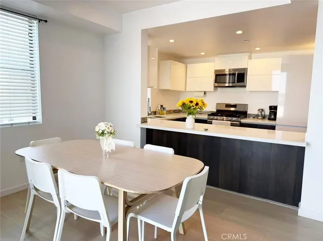 a kitchen with a dining table chairs and refrigerator