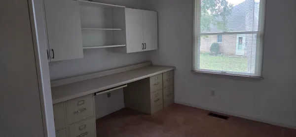 a view of a room that has a large window and wooden floor