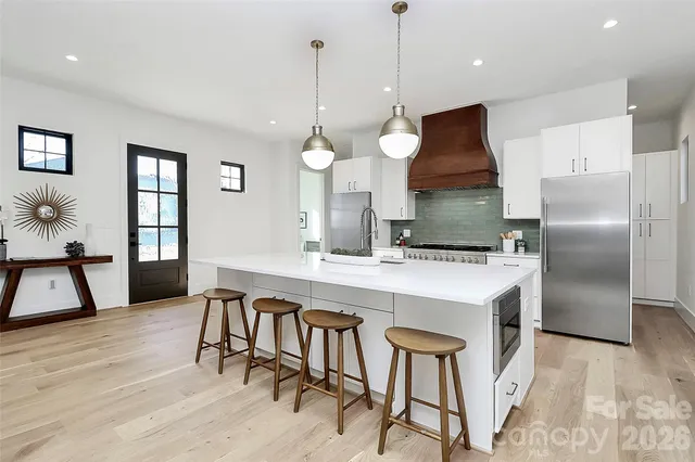 a large kitchen with kitchen island a stove a sink a center island and cabinets