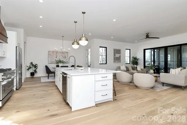 a view of a dining room with furniture a potted plant and wooden floor